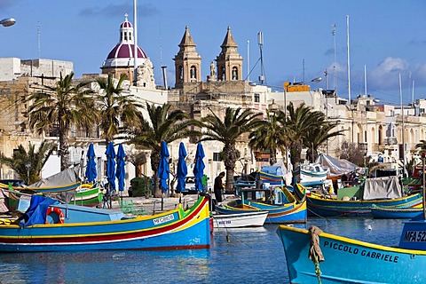 Traditional Maltese fishing boats, called Luzzu, in front of the Church of Our Lady of Pompeii, port of Marsaxlokk, Malta, Europe