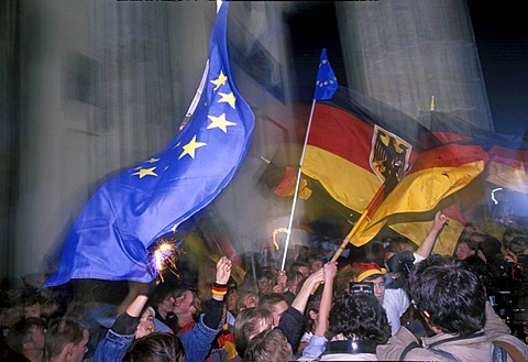 German flags, citizens of Berlin celebrating the reunion of East and West Germany in front of the Brandenburger Tor at night, DDR, October 3rd 1990, Berlin, Germany, Europe