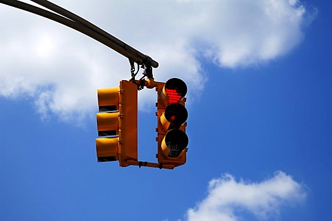 Yellow traffic light in front of blue sky in Newton, New Jersey, USA