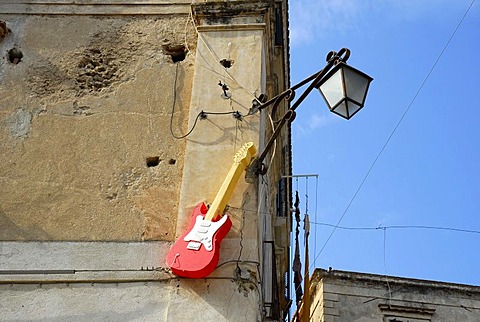 Street lamp, red electric guitar on the facade of the Max Bar in the historic centre of Tropea, Vibo Valentia, Calabria, South Italy, Europe