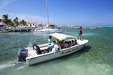 Diving boat loaded with scuba divers heads out to sea, San Pedro, Ambergris Cay Island, Belize, Central America, Caribbean