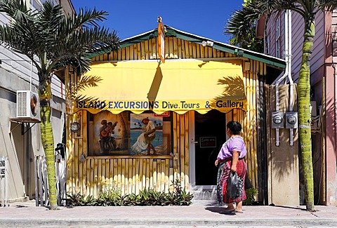 Shop made of bamboo between two palm trees, pedestrian woman, in San Pedro, Ambergris Cay Island, Belize, Central America, Caribbean