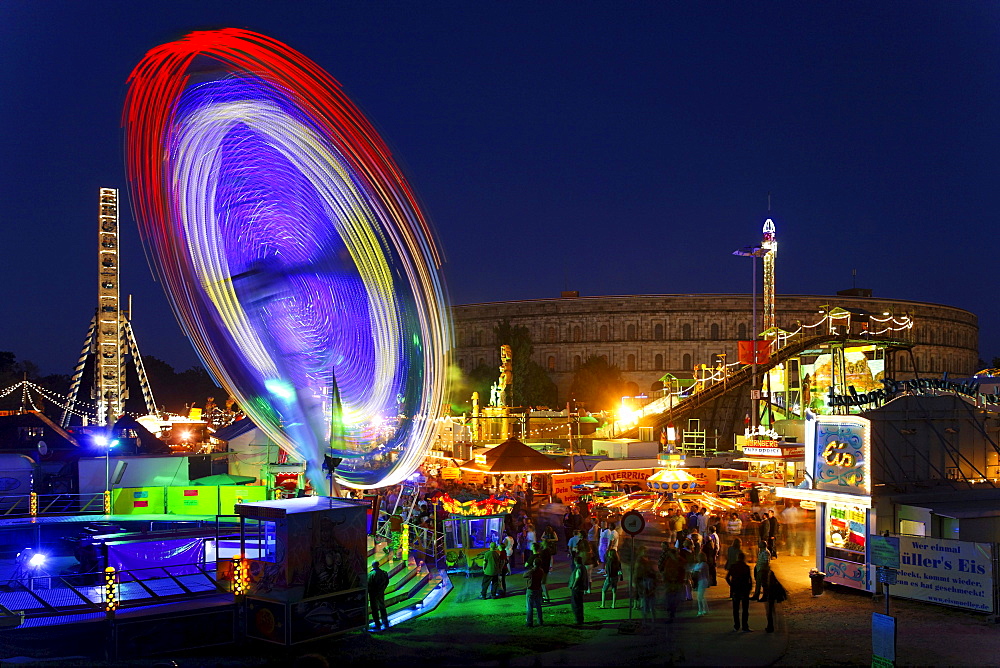 Carousel, autumn folk festival, springtime festival in the evening on the Nazi party rally grounds in front of congress hall, people, Nuremberg, Middle Franconia, Bavaria, Germany, Europe