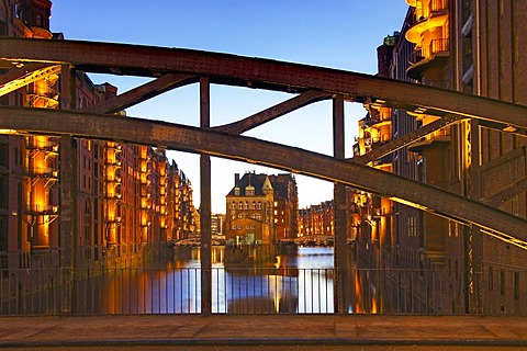 View through Poggenmuehlenbruecke bridge towards Wasserschloesschen, water castle, in Speicherstadt, old warehouse district, in evening light, port of Hamburg, Hamburg, Germany, Europe