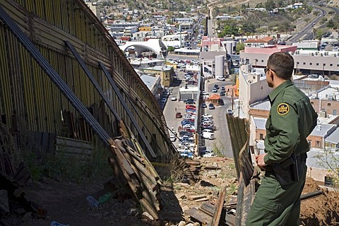 A US Border Patrol agent stands by the border fence that separates the United States and Mexico, Nogales, Arizona, USA