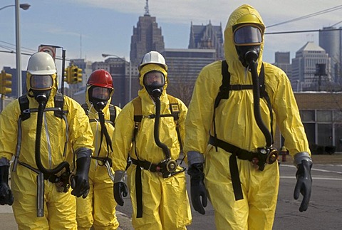 During a training session for workers dealing with toxic chemical spills, participants in protective suits walk down the street, Detroit, Michigan, USA