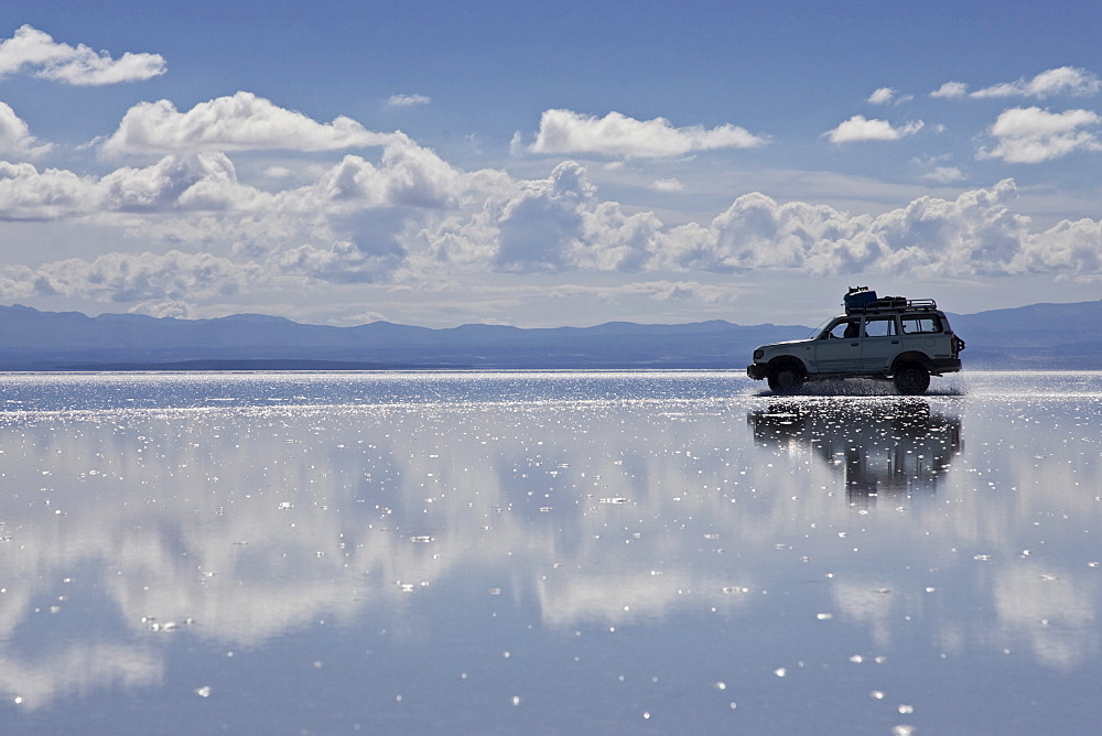 Driving car on the salt lake Salar de Uyuni, Altiplano, Bolivia, South America