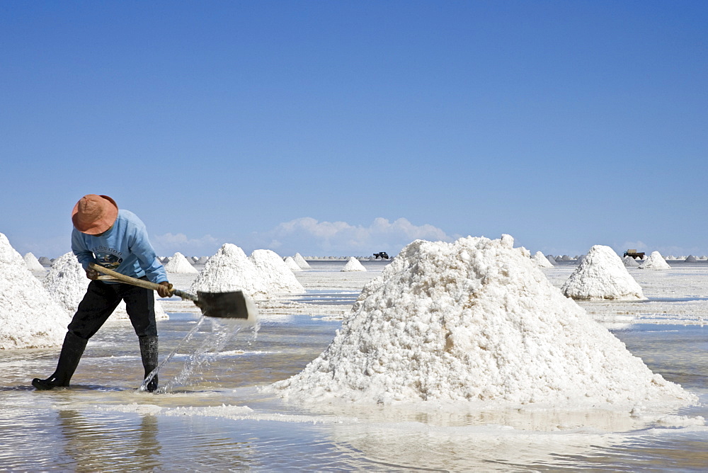 Salt worker makes Salt accumulation, salt lake Salar de Uyuni, Altiplano, Bolivia, South America