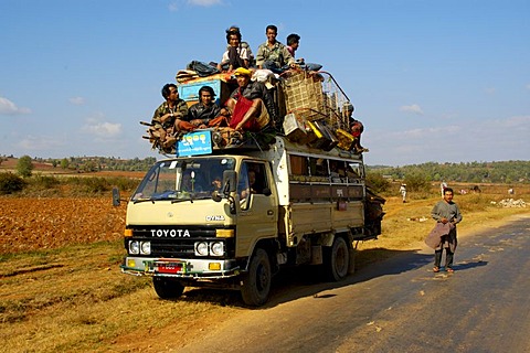 Many men and luggage pile up on the roof of a small Toyota lorry near Pindaya Shan State Burma