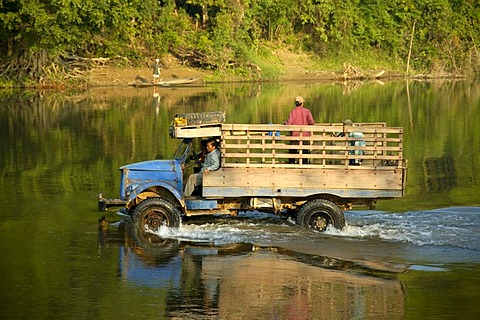 Old lorry drives through water Vang Vieng Laos