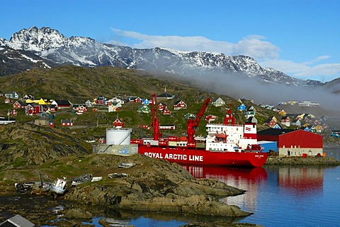 Container ship of Royal Arctic Line in the harbour of the city with colourful houses Ammassalik Eastgreenland