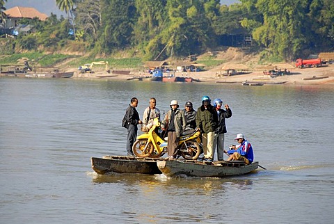 Adventurous ferry with people and a motobike across the Mekong River Champasak Laos