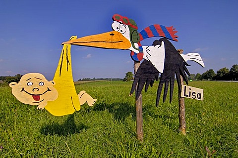 Wooden sign of a stork in a field, newborn baby, Upper Bavaria, Germany