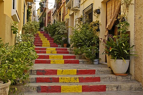 Steep lane with stairway steps in the Spanish national colors, old part of town of Calpe, Costa Blanca, Spain