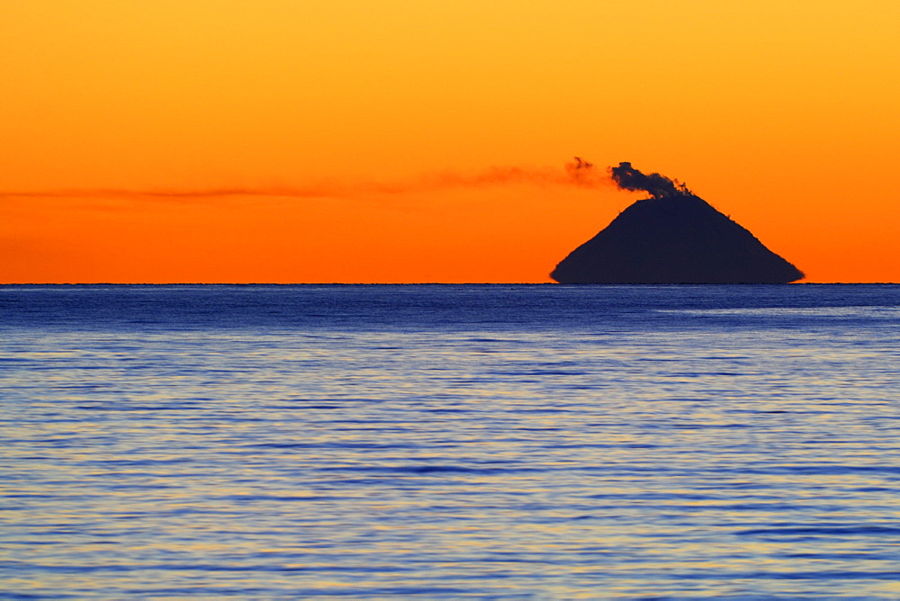 Smoke coming from Mt. Augustine Volcano (Ring of Fire) at sunset, picture taken from ca 140 km away, Kenai Peninsula, Alaska, USA