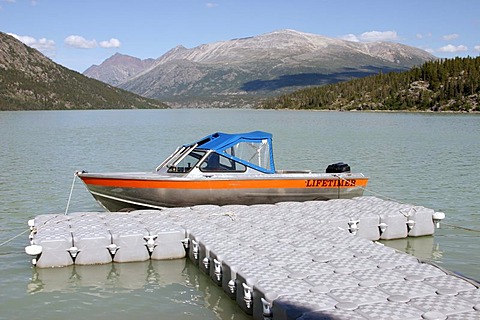 Footbridge made aot of plastik pontoons and the motor boat of the ranger at the Lake Lindemann Chilkoot Trail British Columbia Canada