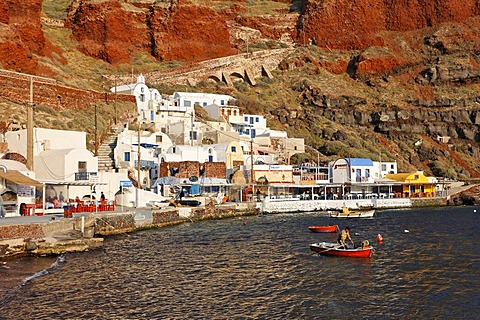 A fishermen in his small rowing boat, harbour of Ammoudi, Oia, Santorini, Greece