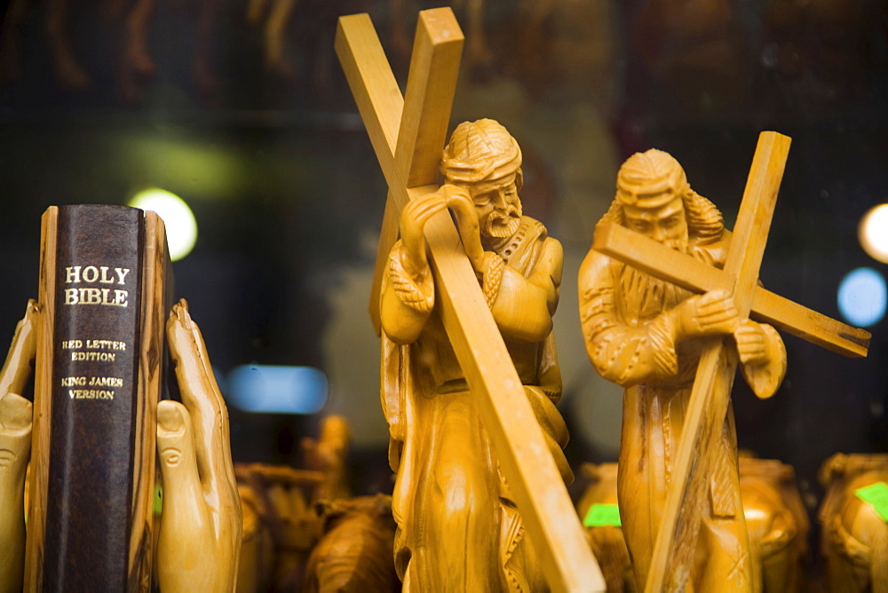 Two carved wooden figures of Jesus carrying the cross and praying hands as bookends, bible, Bethlehem, West Bank, Palestine, Israel, Middle East