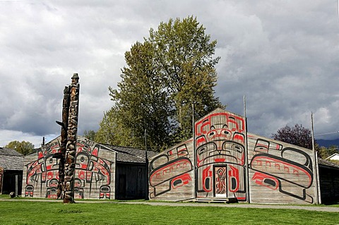 Totem pole in front of long houses at Ksan Historical Village, British Columbia, Canada