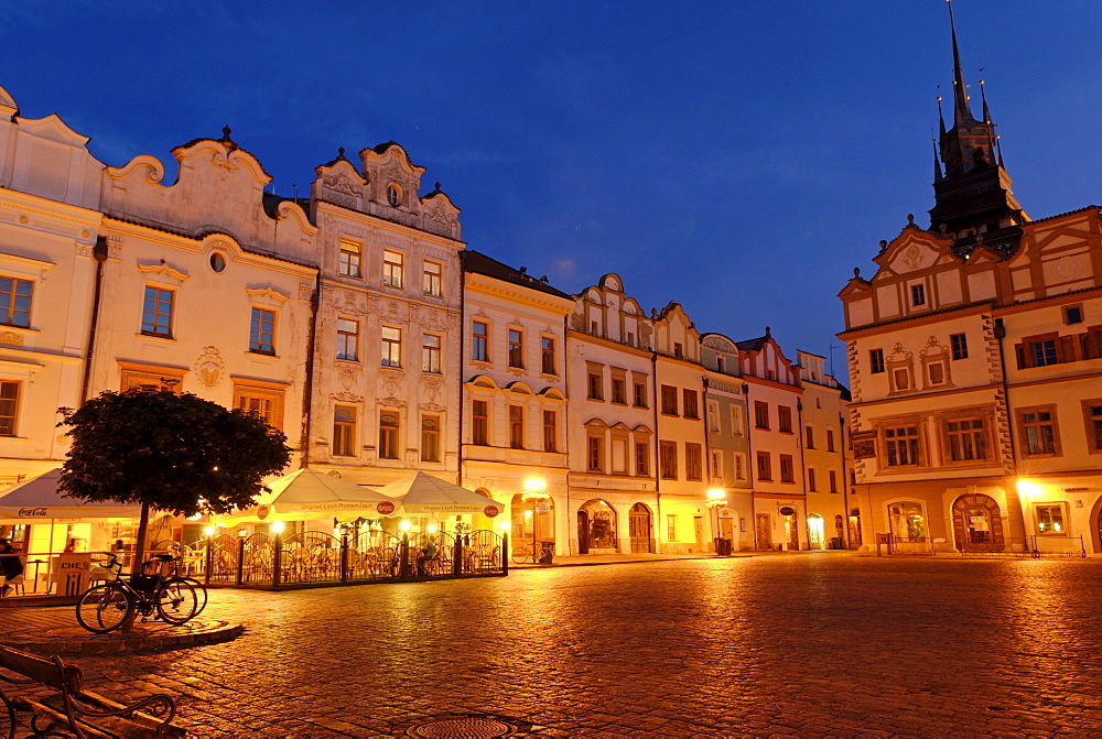 Ornate facade of buildings under streetlights at twilight surrounding the cobbled town square in the historic centre of Pardubice, Pardubice, East Bohemia, Czech Republic, Czechia, Europe