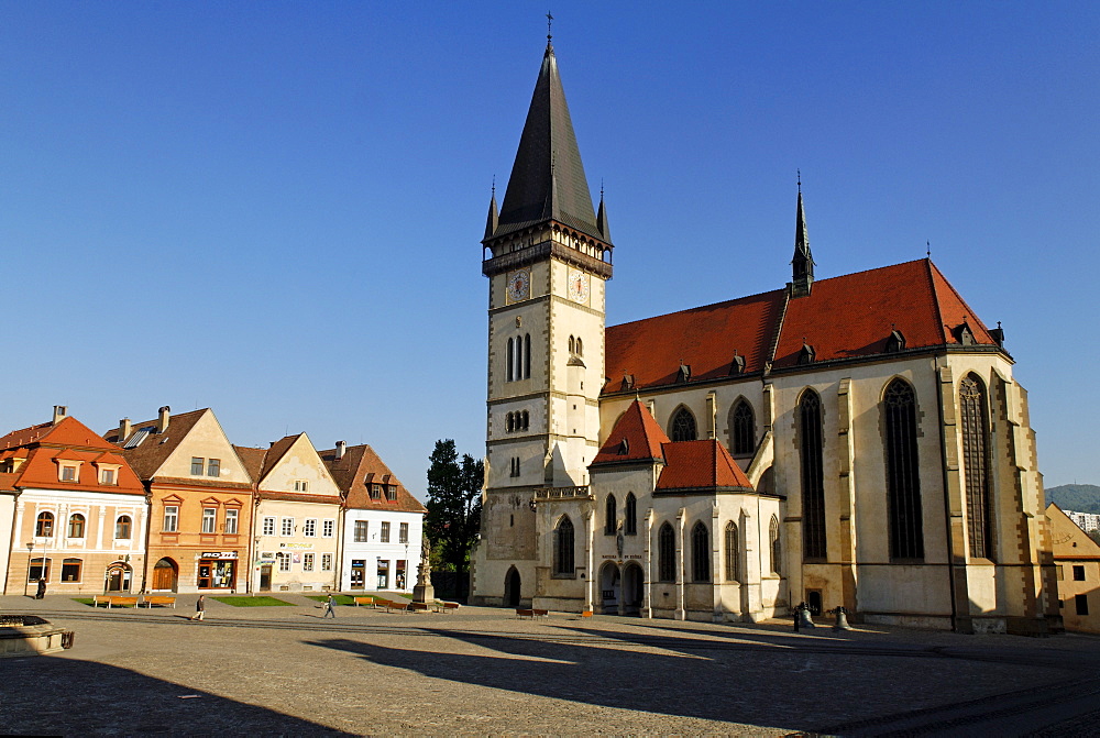 Historic town square of Bardejov surrounded by park benches, a church and old renovated terraced buildings, a UNESCO World Heritage Site, Slovakia, Europe