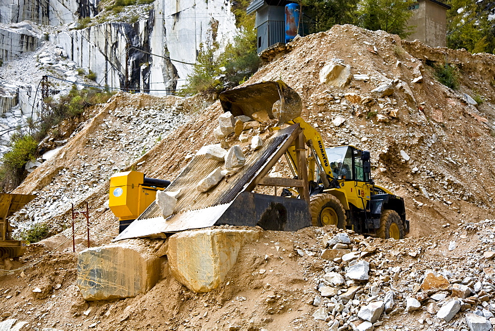 Mechanical shovel excavator at work in the marble stone pit of Carrara Tuscany Italy