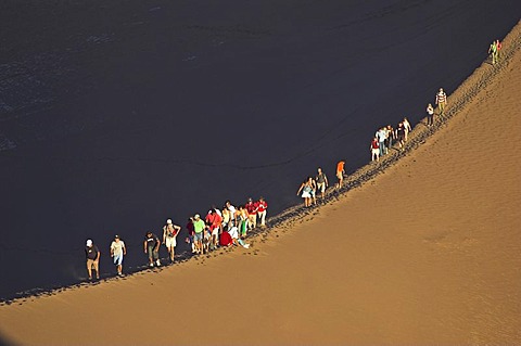 People on a sand dune in the Moon Valley (Valle de la luna), Atacama desert, northern Chile, South America