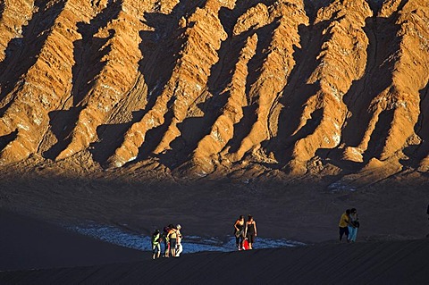 People on a sand dune in the Moon Valley (Valle de la luna), Atacama desert, northern Chile, South America