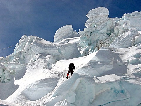 Climber between bizarre ice sculptures of Khumbu Icefall above Base Camp, Mount Everest, Himalaya, Nepal