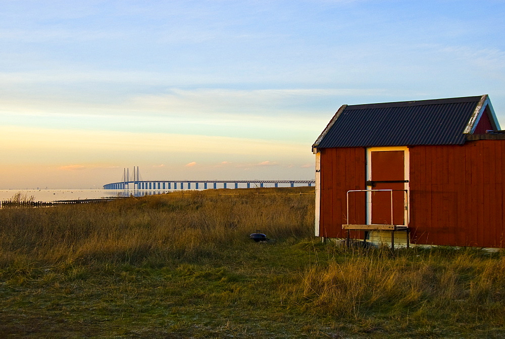 Oeresund Bridge and a red wooden house among the reeds, Skania, Schonen, Sweden, Scandinavia, Europe