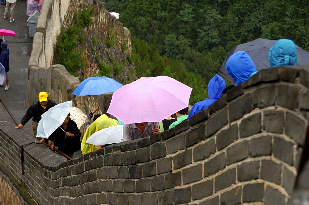 Crowds of tourists push forward on the Chinese Great Wall on a rainy day, China