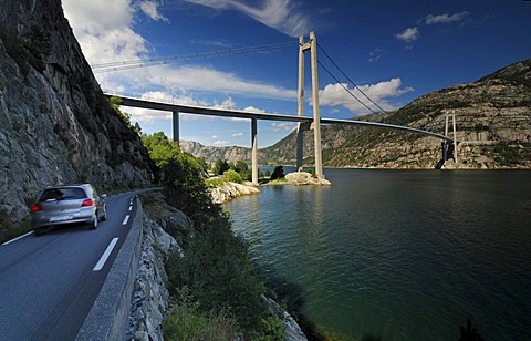 Car driving on a street along the Lysefjord with suspension bridge, Forsand, Rogaland, Norway