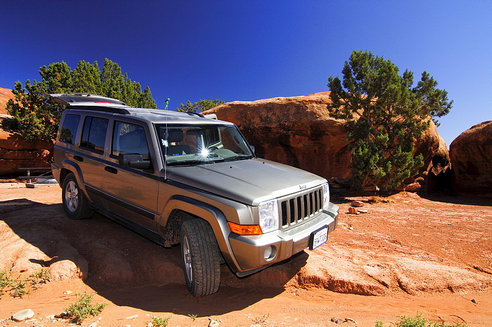 Off-road vehicle Jeep Comander on rocky terrain, Canyonlands, Utah, USA