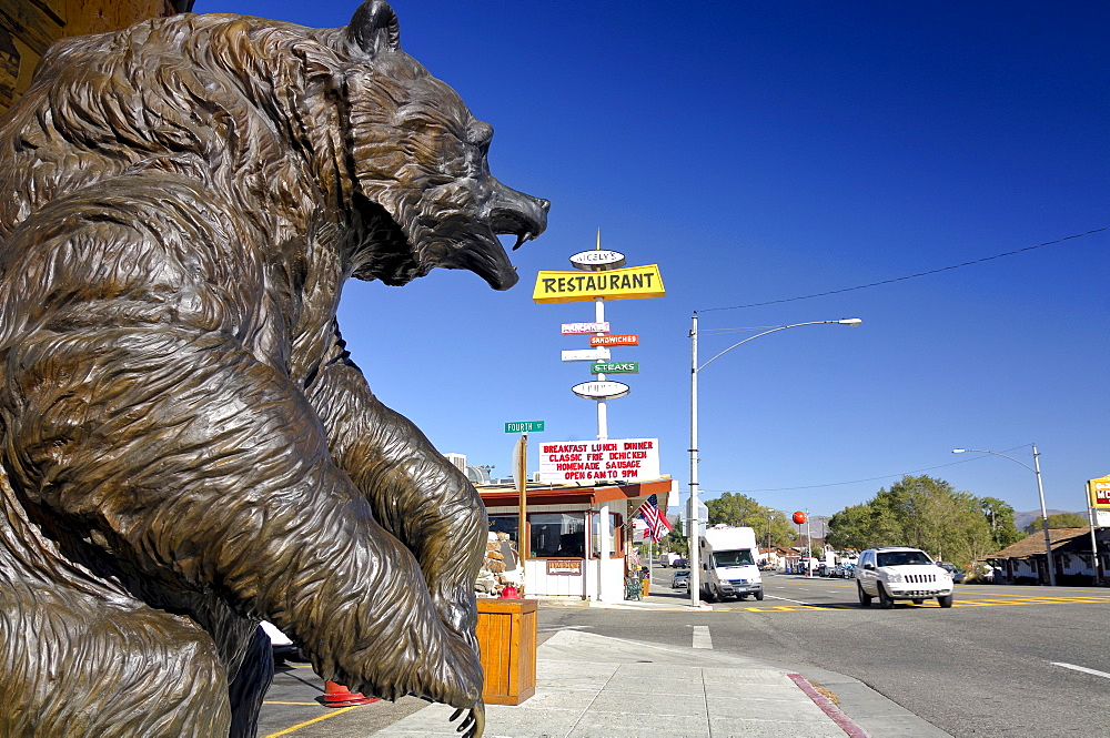 Statue of a brown bear and various billboards lining the main street in Lee Vining near Mono Lake, California, USA, North America