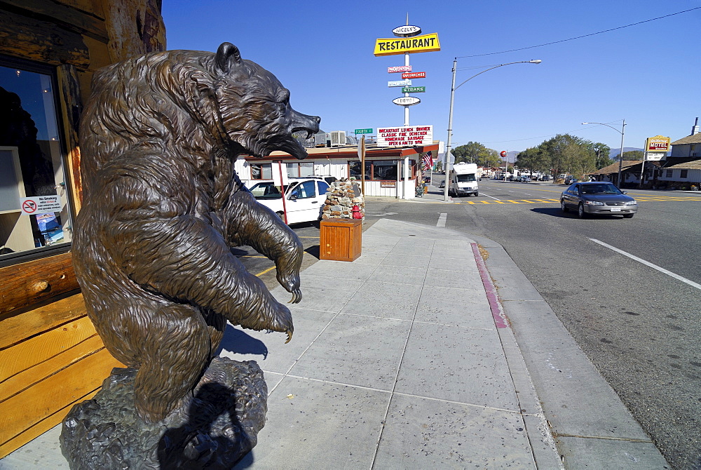 Statue of a brown bear and various billboards lining the main street in Lee Vining near Mono Lake, California, USA, North America