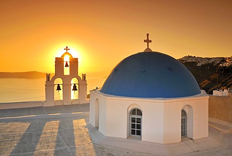 White Greek church with a blue dome and a bell tower at sunset, Firostefani, Santorini, Cyclades, Greece, Europe