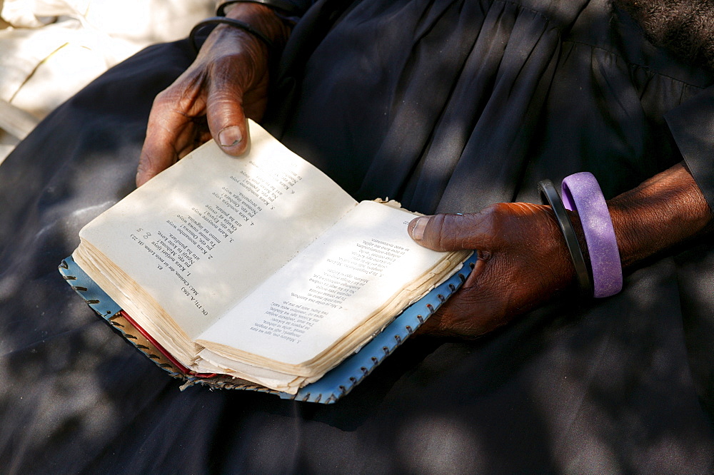 Woman's hands and hymnal, Sehitwa, Botswana, Africa