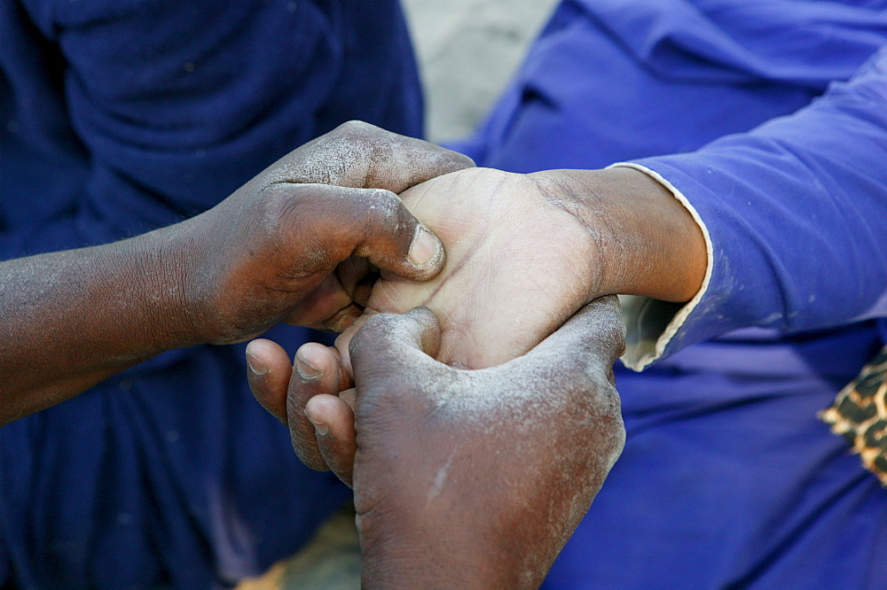 Traditional healer reading the palm of a sick patient, Sehitwa, Botswana, Africa