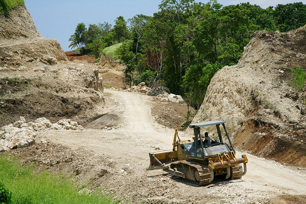 Earth mover building a road for the refinery and harbour area of the Ramu Nickel Mine, chinese mining company, Basamuk, Papua New Guinea, Melanesia