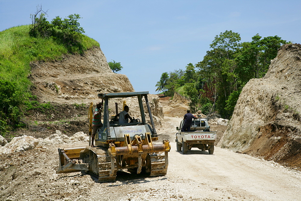 Earth mover building a road for the refinery and harbour area of the Ramu Nickel Mine, chinese mining company, Basamuk, Papua New Guinea, Melanesia