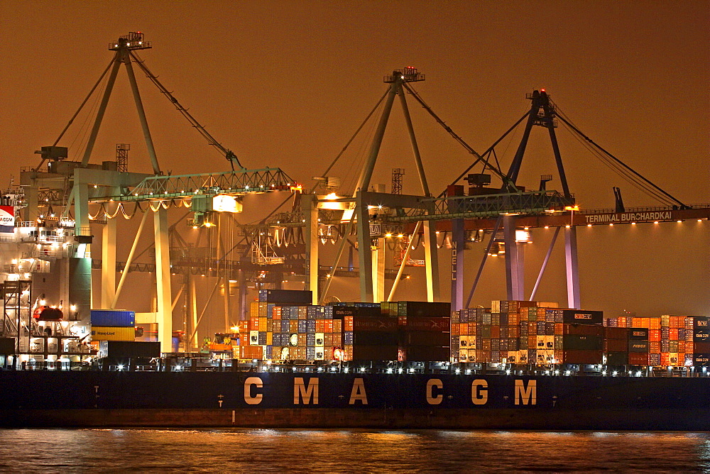 Container ship lying at container terminal Burchardkai in Hamburg harbour at river Elbe in the night - Germany, Europe