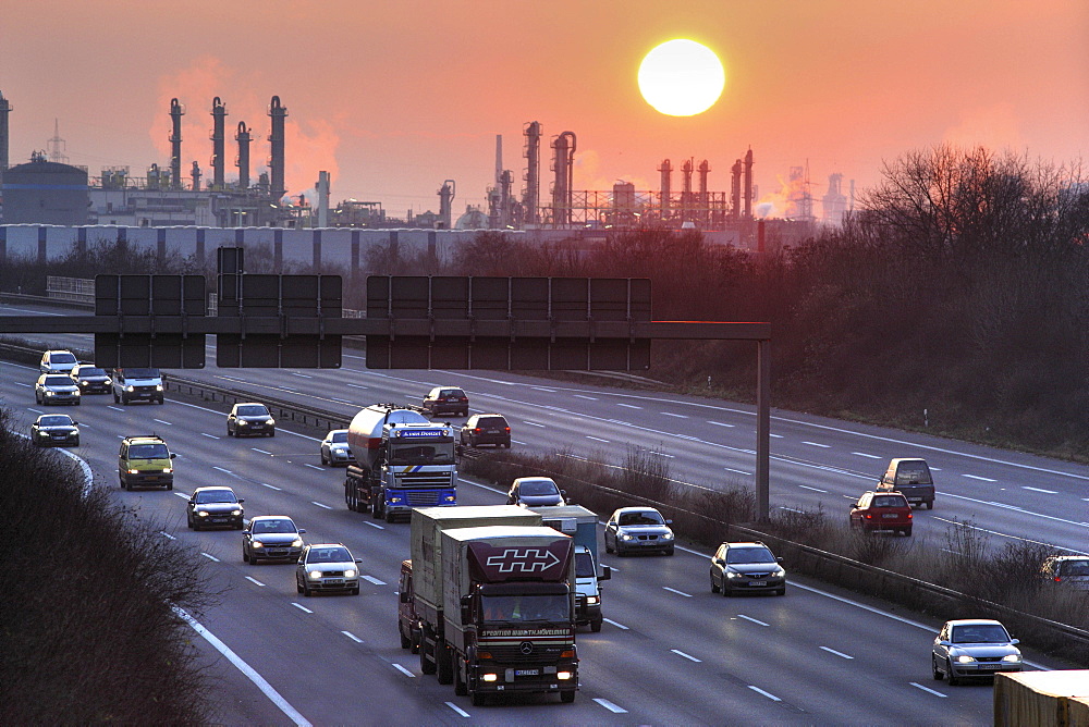 A3 Autobahn (motorway) near Oberhausen-Holten at sunset, OXEA Ruhrchemie chemical plant in background, Oberhausen, North Rhine-Westphalia, Germany, Europe