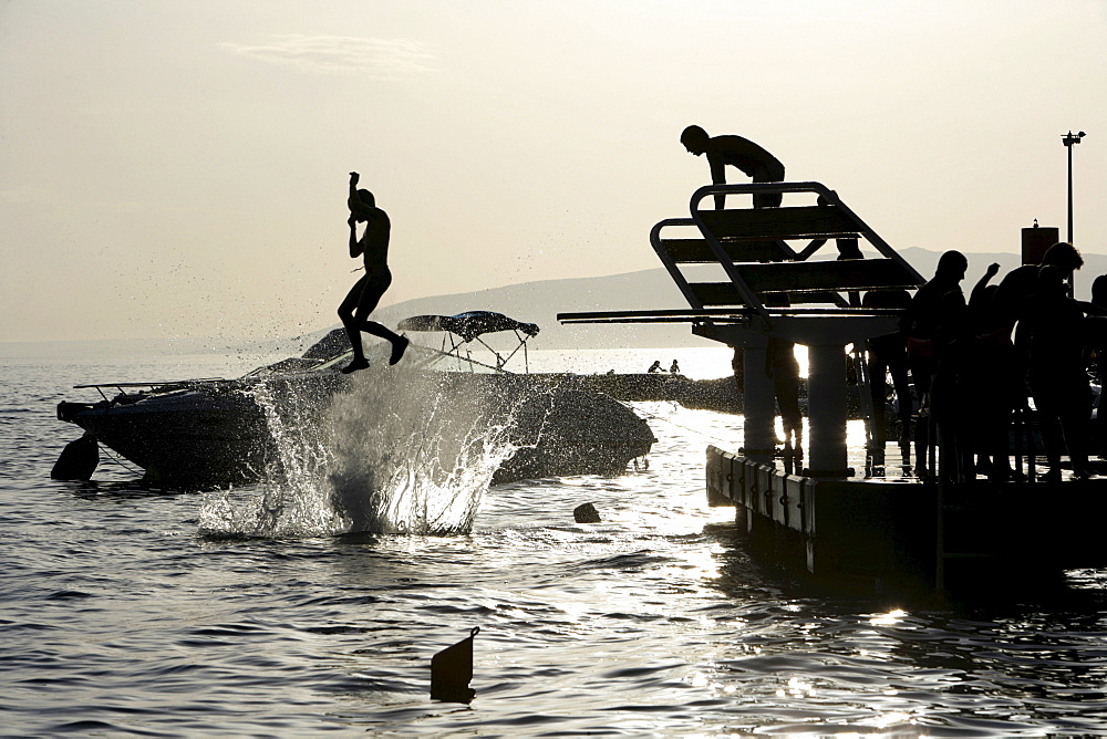 Diving from a dock at Kovacine Campground, with its concrete beach, swimming, and boat docks, Cres Island, Croatia, Europe