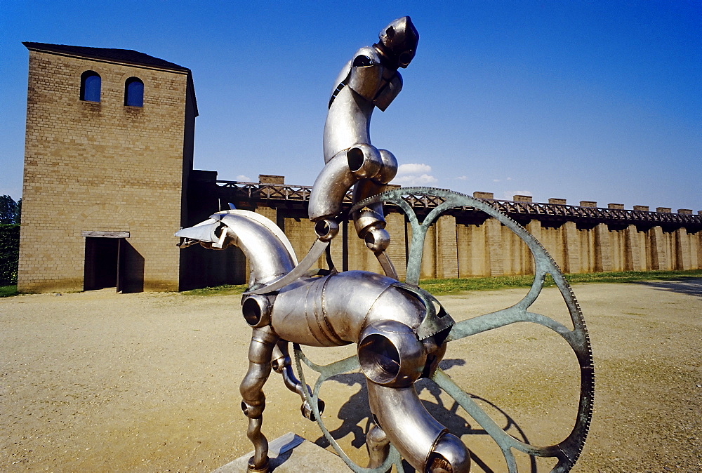 Modern metal plastic horse and rider in front of the reconstructed roman city wall, Xanten Archaeological Park, Lower Rhine, North Rhine-Westphalia, Germany, Europe