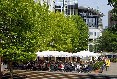 Visitors sitting in front of a sidewalk cafe at the Museumsinsel in the city center of Hamburg, Germany