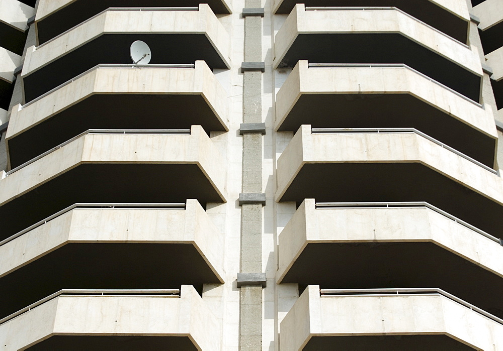 Satellite dish mounted to a balcony on a fortress-like high-rise apartment building in Benidorm, Alicante, Spain