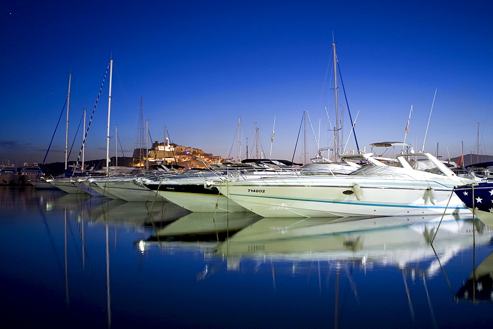 Yachts in the marina of Eivissa in front of the Dalt Vila at dusk, Ibiza, Baleares, Spain