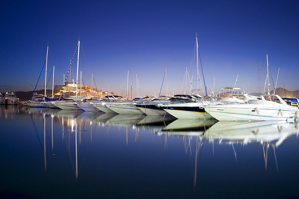 Yachts in the marina of Eivissa in front of the Dalt Vila at dusk, Ibiza, Baleares, Spain