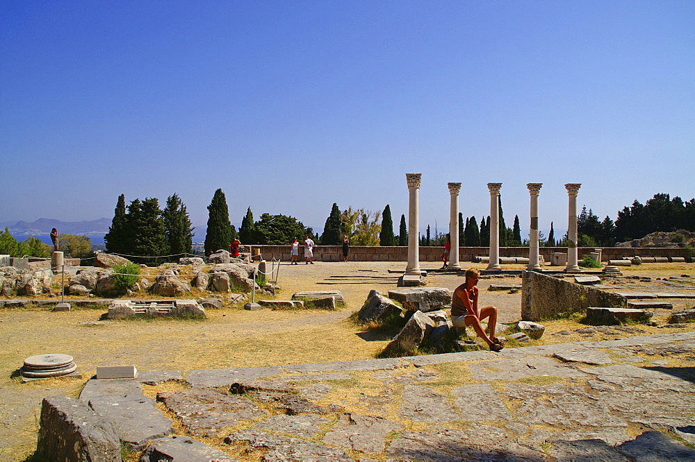 Tourist sitting in front of the ruins at Asklepieion (healing temple), Kos, Dodekanes, Greece, Europe