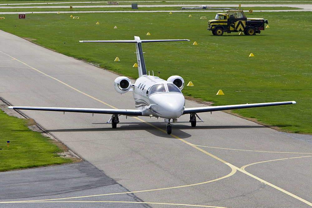 Small, twin-engined business jet taxiing on the runway of Mannheim Airport, Baden-Wuerttemberg, Germany, Europe